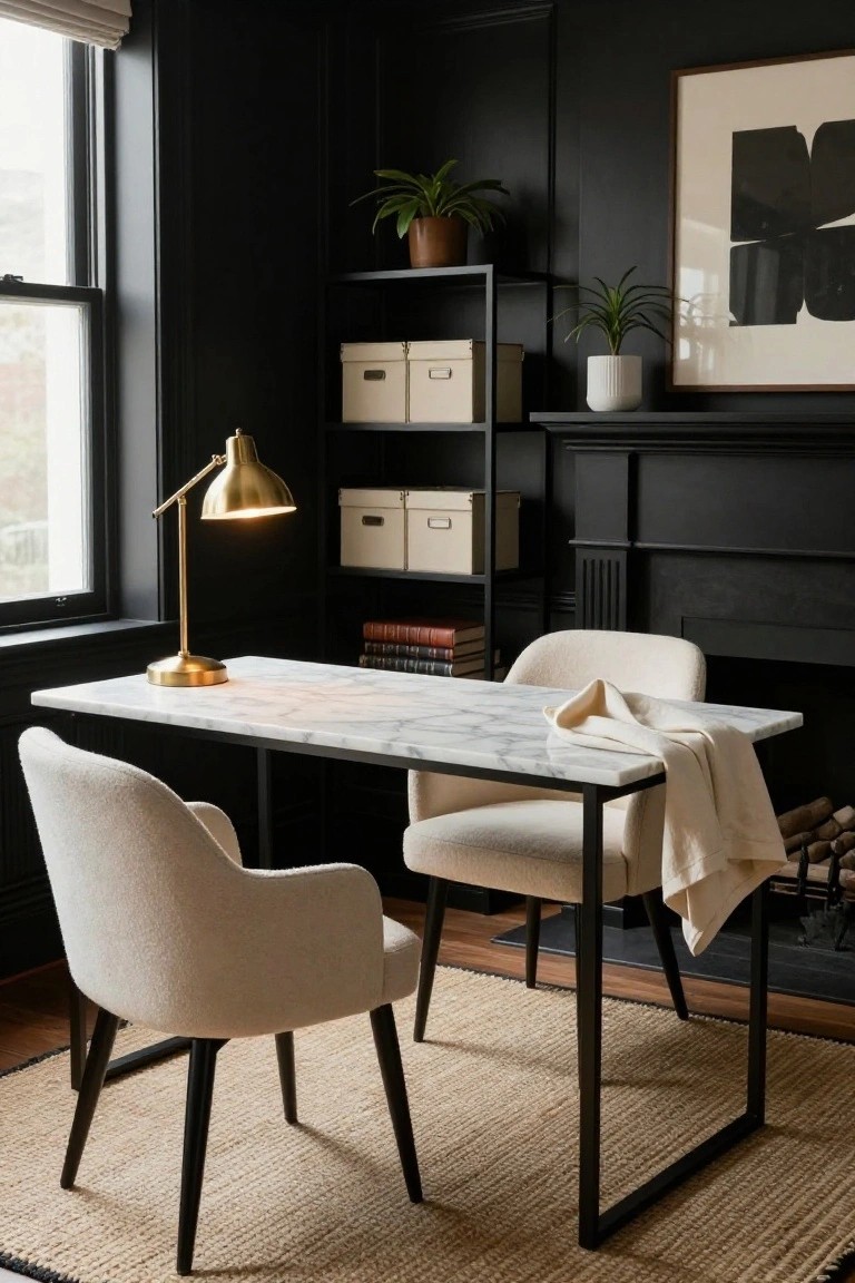 Dark-paneled home office with white marble-top desk on black metal frame, two cream bouclé armchairs, gold desk lamp, black metal shelves holding beige boxes and plants, abstract wall art, and brick fireplace.