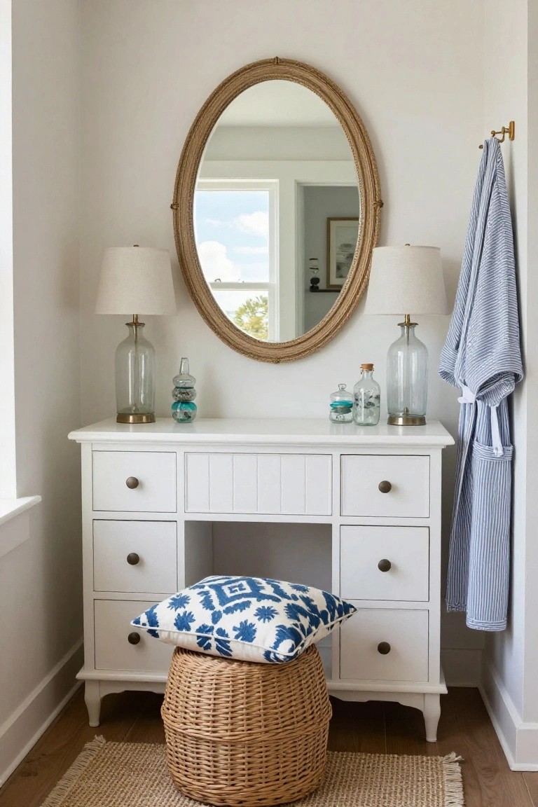 White vanity table with oval mirror, lamps, and woven stool.