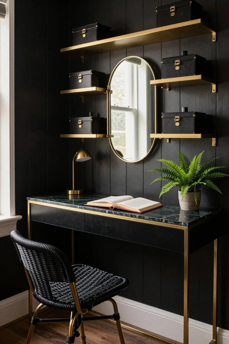 Corner of a home office with black paneled walls, multiple brass floating shelves holding black leather boxes, oval brass mirror, brass desk lamp, open book on green marble-top desk with black body and brass frame, black rattan chair with brass legs, and potted fern on desk.