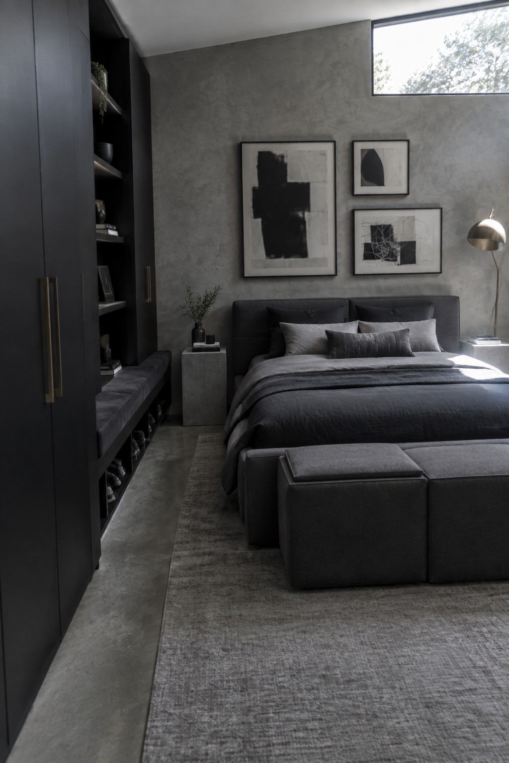 A modern bedroom featuring a tall dark built-in wardrobe with open shelves above a long upholstered bench that has open storage compartments below for shoes.