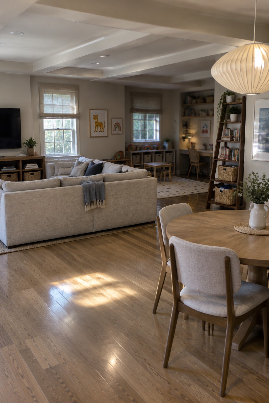 Neutral living room with beige sectional sofa, round wooden table, and sunlit floors